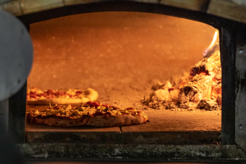Pizza cooking inside a woodfired oven at Embers in the Historic Hayden Granary.