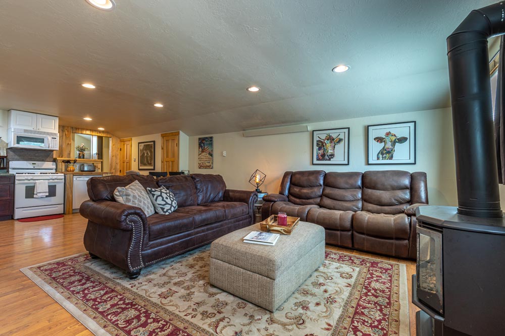 Living room and Kitchen with two sofas, and a fireplace at the Brewery Abode air B&B