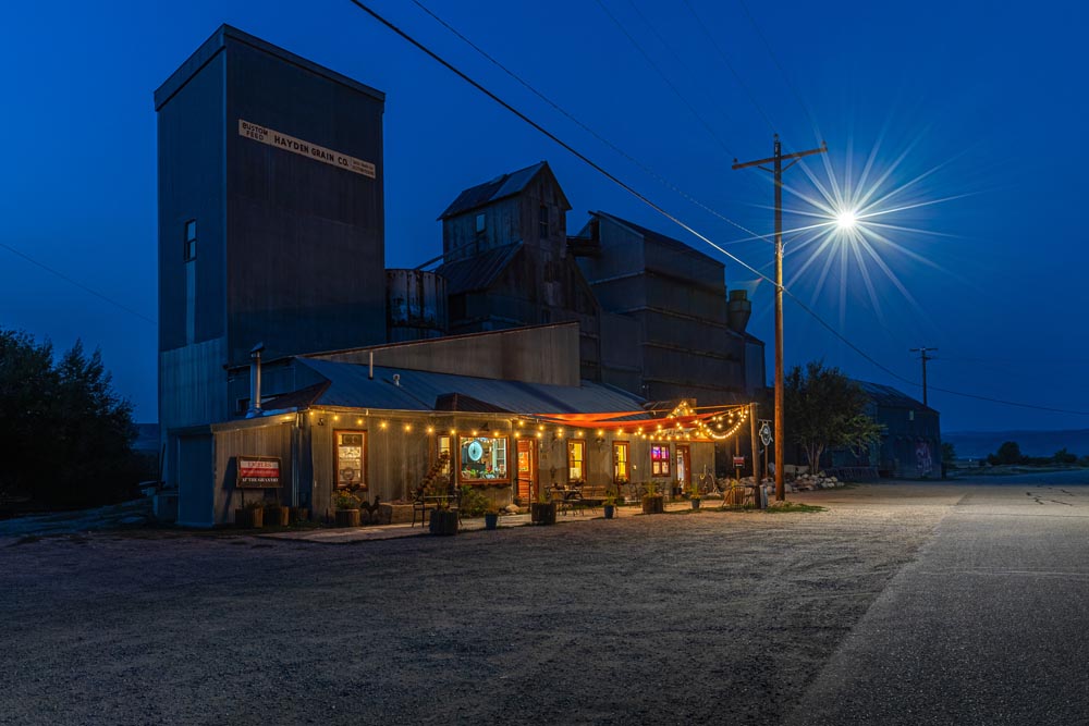 Historic Hayden Granary lit up at night with the moon.