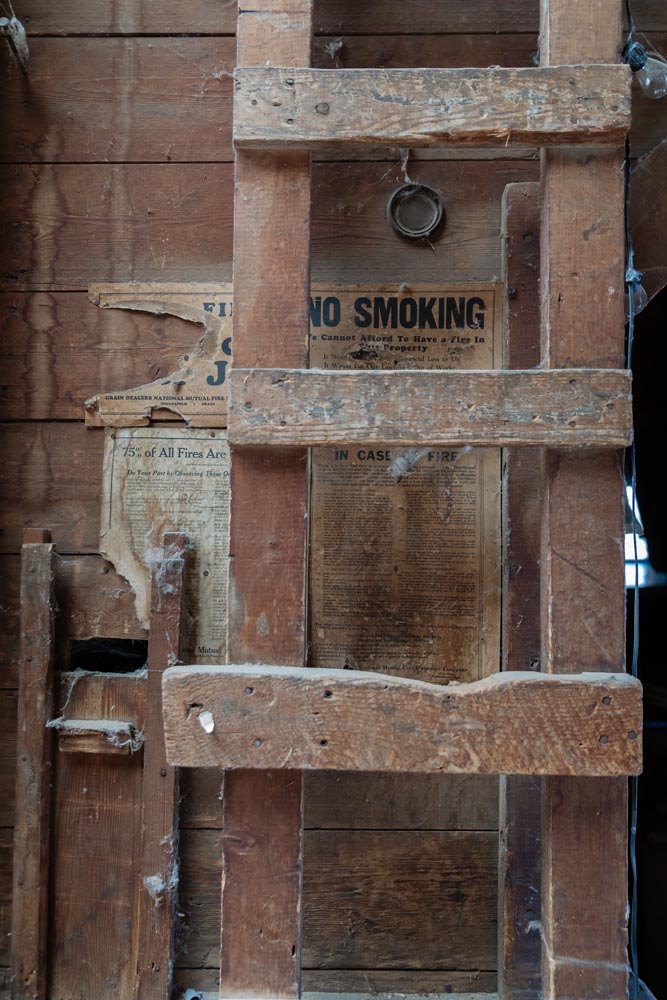 Old newspaper on the wall behind an old wood ladder inside the Historic Hayden Granary.