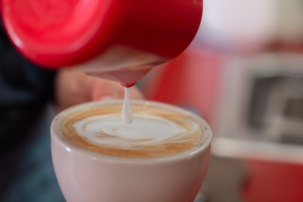 Details shot of steamed milk being poured at the Wild Goose Coffee shop.