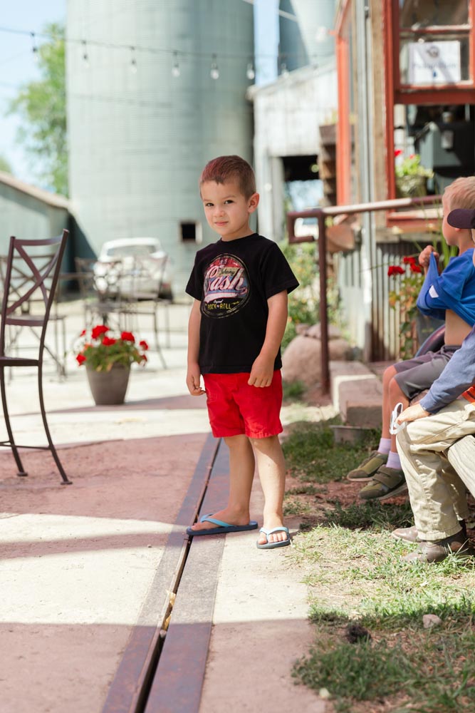 Little boy standing outside of the Wild Goose Coffee shop at the Historic Hayden Granary.