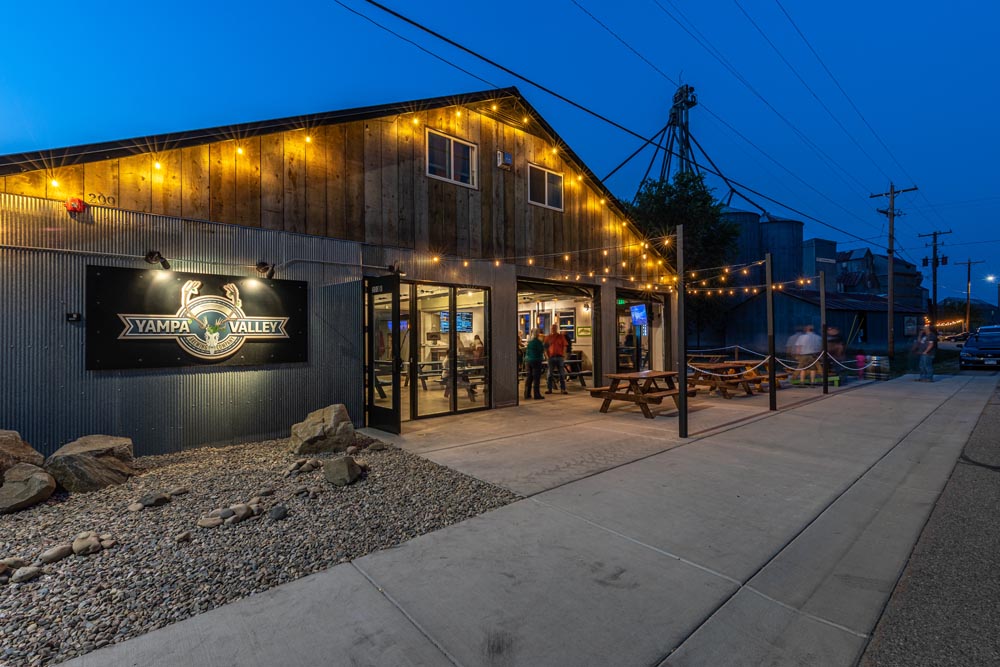 Yampa Valley Brewing lit up at night time with patrols on the patio.